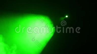 用烟雾机发出的烟雾中的聚光灯发出的一束绿光照亮场景